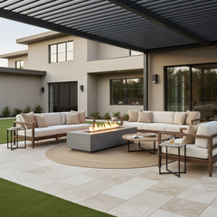 Fire Table Furniture Sets: Ignite Your Patio Game - fire table furniture set on travertine in a residential backyard underneath a pergola with a nice beige stucco home in the background and artificial turf around the travertine